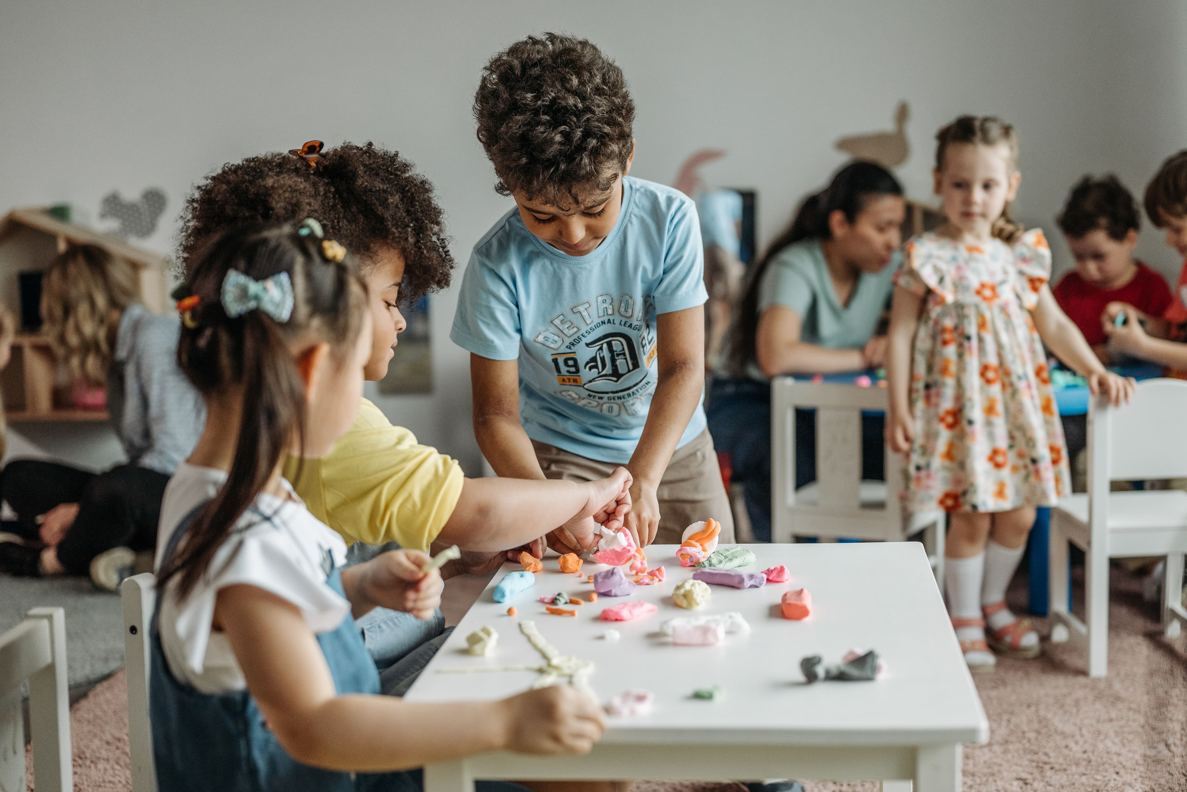 Preschool children playing with colorful modeling clay at a table